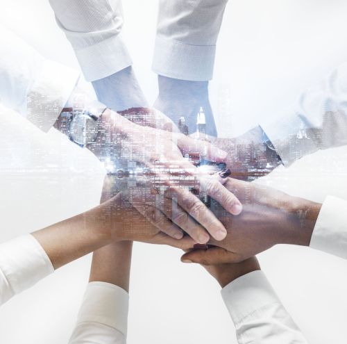 Business team joining hands together city background